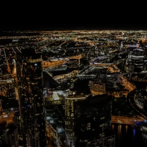 A photo of the Melbourne skyline lit up with yellow neon lights at night